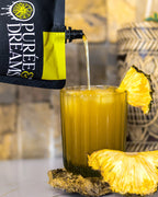 Pineapple purée syrup being poured into a Golden Breeze cocktail